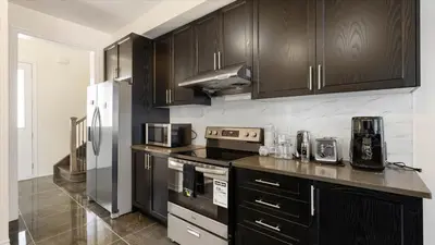 a kitchen with black cabinets and stainless steel appliances at Modern Bay Vista Getaways in Carrying Place