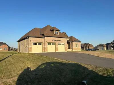 a large brick house with a large garage at Modern Bay Vista Getaways in Carrying Place