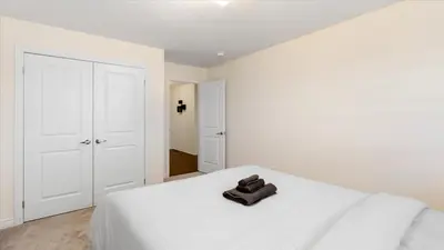 a white bedroom with a white bed with a pair of shoes on it at Modern Bay Vista Getaways in Carrying Place
