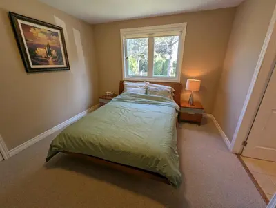 a small bedroom with a bed and a window at Red Brickhouse Lakefront Cottage in Brechin