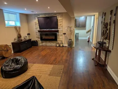 a living room with a fireplace and a flat screen tv at Red Brickhouse Lakefront Cottage in Brechin