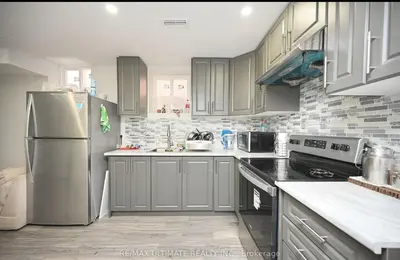 a kitchen with a stainless steel refrigerator and cabinets at Basement in Brampton
