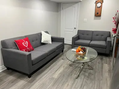 a living room with a couch and a glass table at Basement in Brampton