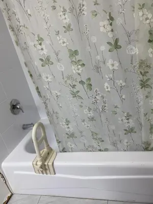 a bath tub with a shower curtain with flowers at Comfy Private Room in Brampton