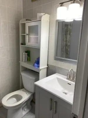a white bathroom with a toilet and a sink at Comfy Private Room in Brampton