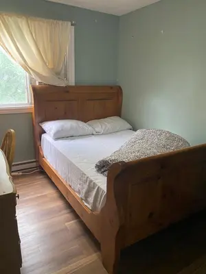 a bedroom with a bed with a wooden frame and a window at Comfy Private Room in Brampton