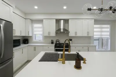 a kitchen with white cabinets and a sink at Lux 3 Bedroom Home near Public Transit in Brampton