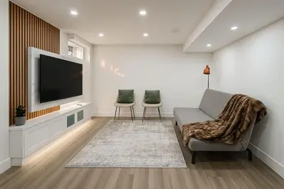 a living room with two chairs and a flat screen tv at Lux Basement Apartment Getaway in Brampton