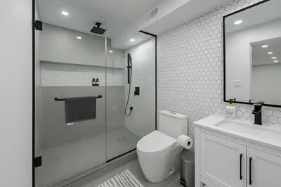 a bathroom with a shower and a toilet and a sink at Lux Basement Apartment Getaway in Brampton