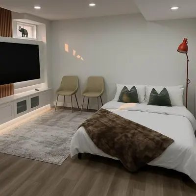 a bedroom with a large bed and a flat screen tv at Lux Basement Apartment Getaway in Brampton