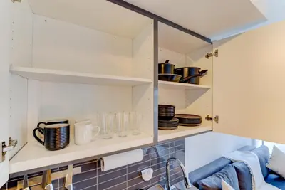 a kitchen with white shelves with cups and dishes at Downtown Luxury Unit in Toronto