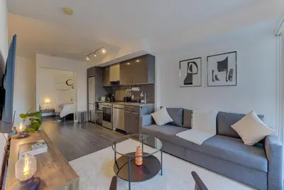 a living room with a blue couch and a kitchen at Downtown Luxury Unit in Toronto