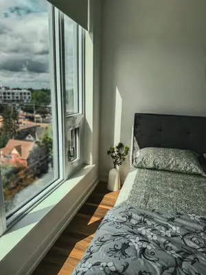 a bedroom with a bed and a large window at LuxCondo in the Downtown Kitchener Uptown Waterloo in Kitchener