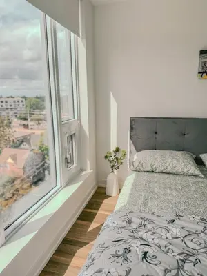 a bedroom with a bed and two windows at LuxCondo in the Downtown Kitchener Uptown Waterloo in Kitchener