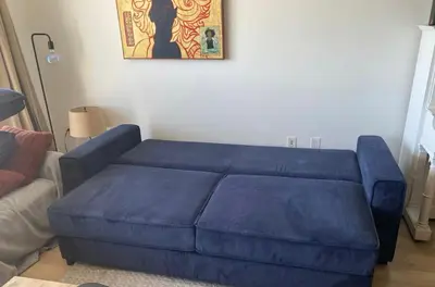 a blue couch sitting in a living room at Downtown Toronto luxury one bedroom one den in Toronto