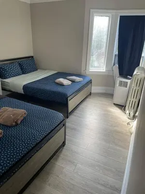 a room with two beds and a window at THE BLOOR AC SUITE-Free Wifi-Train-Bus Stop Next Door in Toronto