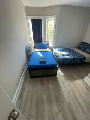 a small room with two beds and a window at THE BLOOR AC SUITE-Free Wifi-Train-Bus Stop Next Door in Toronto
