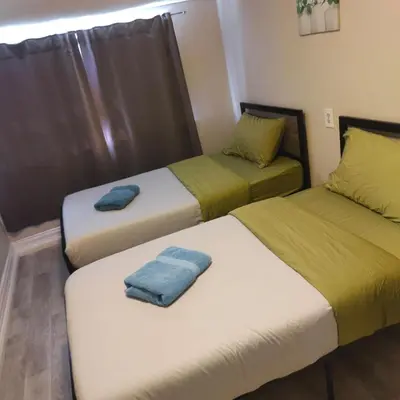 two beds with towels on them in a room at THE BLOOR AC SUITE-Free Wifi-Train-Bus Stop Next Door in Toronto