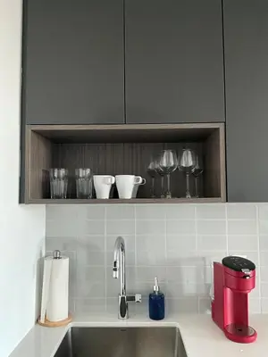 a kitchen with a sink with glasses on a shelf at New Condo With Large Balcony - The Queensway Retreat in Toronto