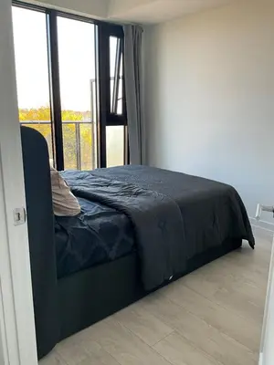 a bed in a room with a large window at New Condo With Large Balcony - The Queensway Retreat in Toronto