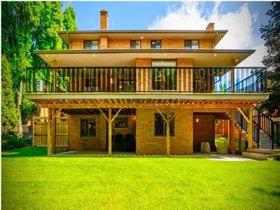 a large house with a balcony on top of a yard at Luxurious Pvt room & Pvt heated floor bathroom near Airport in Kitchener