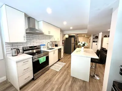 a kitchen with white cabinets and a black stove top oven at Luxurious Pvt room & Pvt heated floor bathroom near Airport in Kitchener