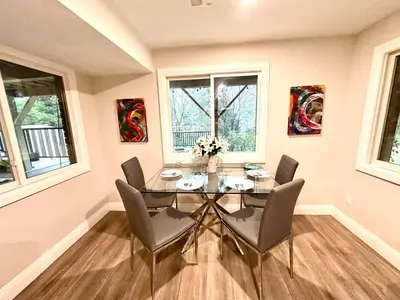 a dining room with a glass table and chairs at Luxurious Pvt room & Pvt heated floor bathroom near Airport in Kitchener