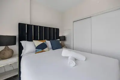 a white bed with a black headboard in a bedroom at Skyline Escape • 3BR Penthouse with Terrace in Toronto