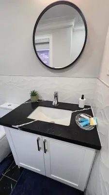 a bathroom with a sink and a mirror at Toronto Guest House in Toronto