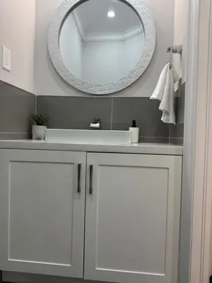 a bathroom with a white sink and a mirror at Toronto Guest House in Toronto