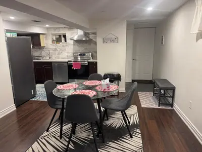 a kitchen and dining room with a table and chairs at Stylish 2Bedroom Basement Suite in Oakwood Village in Toronto