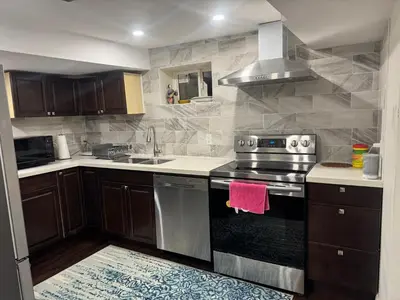 a kitchen with a stove and a sink at Stylish 2Bedroom Basement Suite in Oakwood Village in Toronto