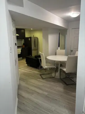 a room with a table and chairs and a kitchen at Ame place in Brampton