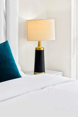 a lamp sitting on a bed with a blue pillow at Stylish 3BR Penthouse with Stunning City Views in Toronto