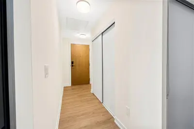 an empty hallway with white walls and a door at Stylish 3BR Penthouse with Stunning City Views in Toronto