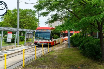 a red bus is parked at a train station at Stylish 3BR Penthouse with Stunning City Views in Toronto