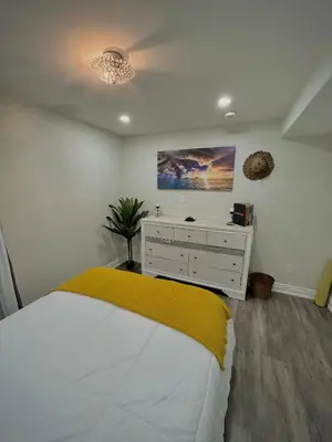 a bedroom with a bed and a dresser in it at Your cozy Caribbean-inspired stay just 1 hour north of Toronto in Alliston