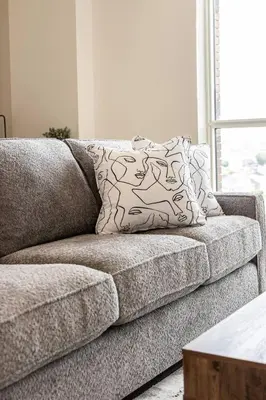 a couch with a pillow on it in a living room at Elegant 4BR Condo with City Views & Free Parking in Toronto
