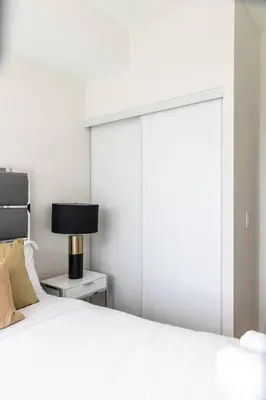a bedroom with a white bed with a sliding door at Elegant 4BR Condo with City Views & Free Parking in Toronto