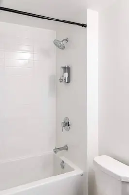 a white bathroom with a tub and a toilet at Elegant 4BR Condo with City Views & Free Parking in Toronto