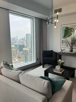 a living room with a couch and a large window at INFIVILLA King Suites & Towers Eaton Toronto in Toronto