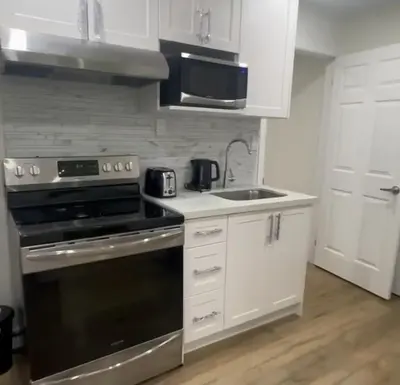 a kitchen with a black stove and a sink at 2 Bedroom private Basement apartment in Markham