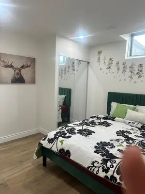 a bedroom with a bed and a deer on the wall at 2 Bedroom private Basement apartment in Markham