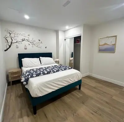 a bedroom with a bed with a blue bed frame at 2 Bedroom private Basement apartment in Markham