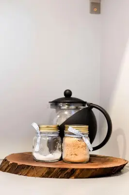 a tea pot and a jar of bread on a wooden board at Stylishly Remodeled Queen Victoria Loft in Niagara Falls