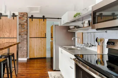 a kitchen with a sink and a stove at Stylishly Remodeled Queen Victoria Loft in Niagara Falls