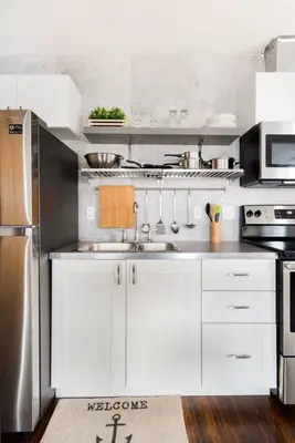 a kitchen with white cabinets and a stainless steel refrigerator at Stylishly Remodeled Queen Victoria Loft in Niagara Falls