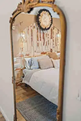 a mirror in a bedroom with a bed in it at Crystal Beach Executive Waterfront Lakehouse in Fort Erie