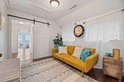 a living room with a yellow couch and a table at Crystal Beach Executive Waterfront Lakehouse in Fort Erie