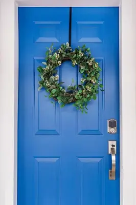 a blue door with a wreath on it at Wood-Rich Niagara Loft close to Queen Street in Niagara Falls